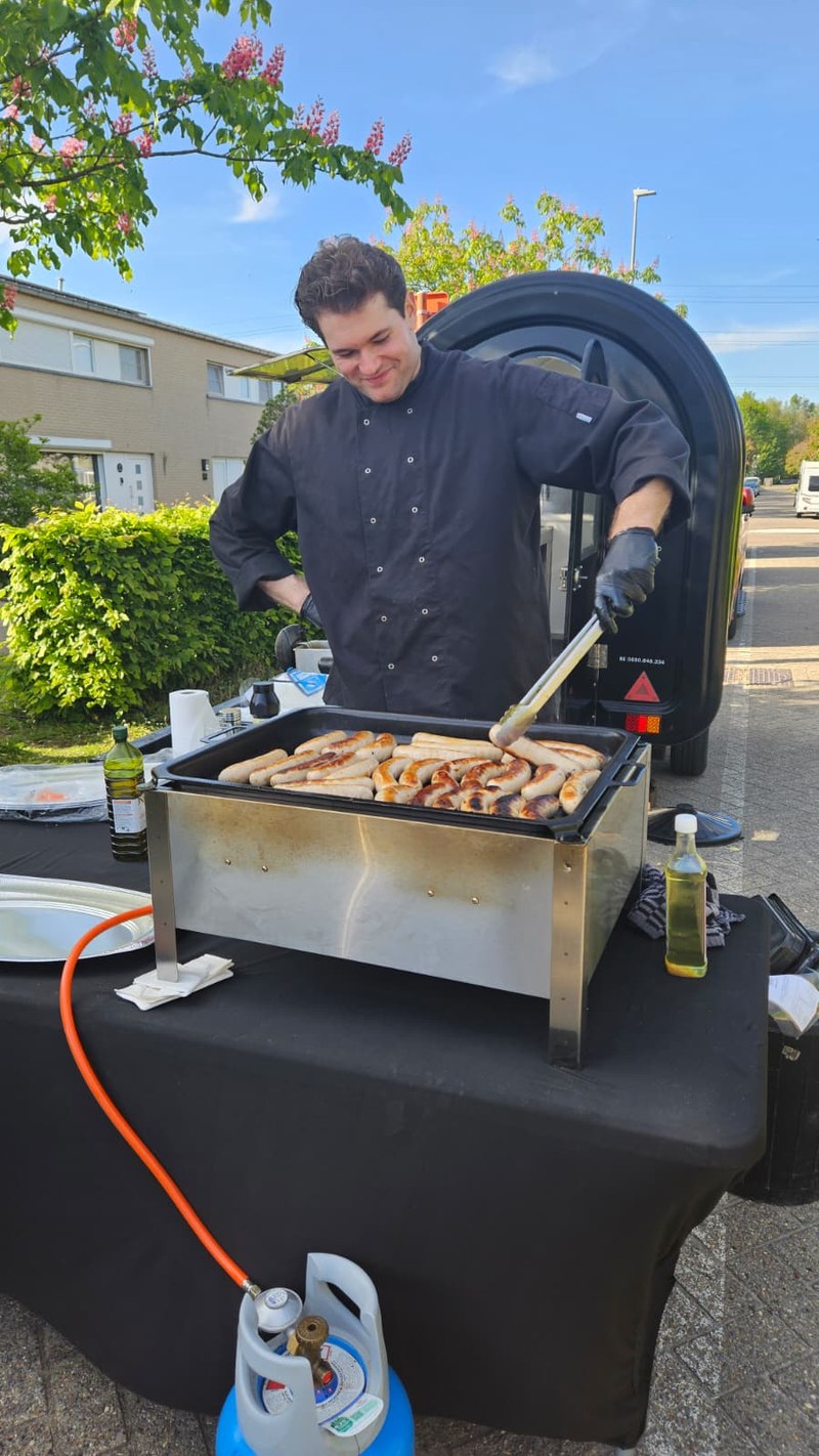 Adriano grilt verse worstjes bij de foodtruck