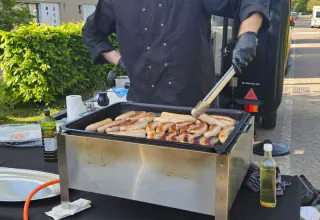 Adriano grilt verse worstjes bij de foodtruck